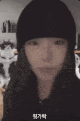 a woman in a black hat stands in front of two cats and a computer monitor