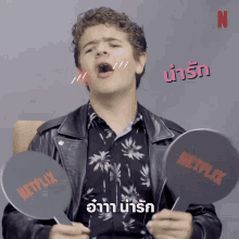 a young man is holding up a netflix sign