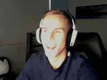 a man wearing headphones is sitting in a chair and smiling