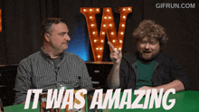 two men are sitting at a table and one of them is pointing and the words it was amazing are displayed