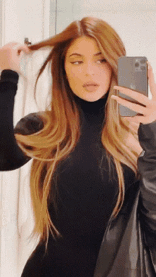 a woman taking a picture of herself in a mirror