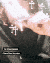a close up of a person 's face with crosses around their neck