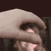 a close up of a person 's hand touching another person 's head .