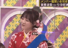 a woman in a red and white kimono is holding a blue ribbon .
