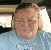 a woman wearing a blue shirt with a mouse on it