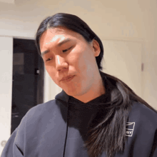 a man with long hair wearing a black hoodie that says iggy