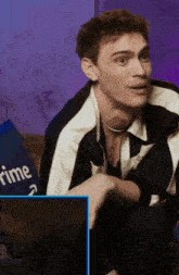 a man sitting on a couch with a pillow that says prime on it