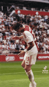 a soccer player wearing a number 25 jersey is jumping in the air