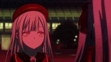 a girl in a red hat is smiling in a red light
