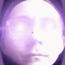 a close up of a woman 's face with a purple light coming out of her eyes .