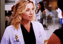 a woman wearing a white lab coat with a patch that says ' surgical hospital ' on it