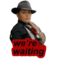 a woman wearing a hat and a suit has a sticker that says we 're waiting