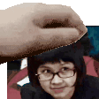 a hand is holding a woman 's head in front of a woman wearing glasses .