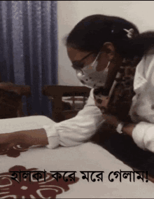 a woman wearing a mask is laying on a bed with a foreign language caption