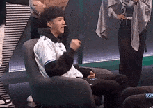 a man is sitting in a chair with his fist in the air