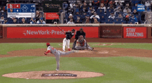 a baseball game is being played in front of a new york-presbyterian ad