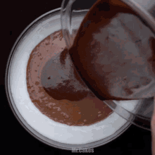 chocolate is being poured into a bowl with the words mr.cakes below