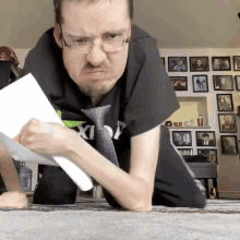 a man wearing glasses and a black shirt that says ' x1 ' on it