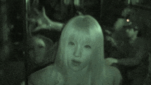 a blurred image of a woman 's face with a green background