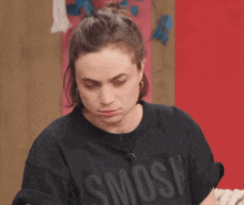 a woman wearing a black t-shirt with the word smosh on it