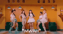 a group of girls are dancing in a room and the word mwah is on the bottom right