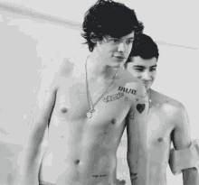 a shirtless man with a tattoo on his shoulder that says " i love you "
