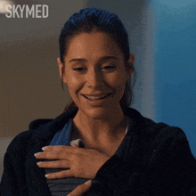 a woman is smiling in front of a skymed logo