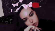 a woman with pink butterflies on her forehead is laying on a bed