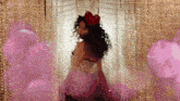 a woman with a red heart on her head stands in front of a curtain