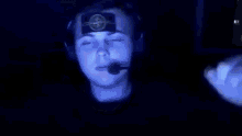 a man wearing headphones and a microphone has a picture of a cat on his face .