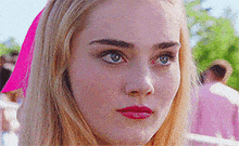 a close up of a woman 's face with a pink headband on .