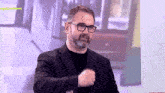 a man with glasses and a beard stands in front of a screen that says " egolivenews "
