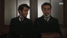 two men in suits and ties are standing next to each other with hbo written on the bottom right corner