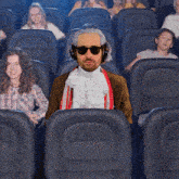 a man is taking a picture of himself in a crowded theater