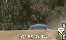 a car is driving down a dirt road with the words `` jones omw '' written on the screen .
