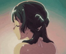 a close up of a girl 's back with her eyes closed and a bun in her hair .