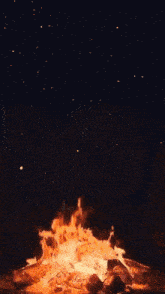 a heart shaped object is floating over a campfire