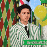 a man in a green and white striped suit with balloons in the background