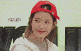 a woman wearing a red hat with the letters b18 on it