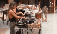 two women are preparing food in a kitchen with pots and pans on the counter