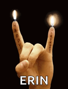 a person 's hand is making a rock sign with candles on their fingers .