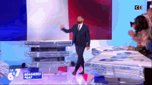 a man in a suit and tie walks on a stage with a sign that says le 67