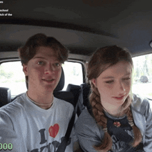 a boy and a girl are sitting in the back seat of a car and the girl has a shirt that says i love ny