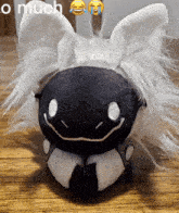 a black and white stuffed animal with a caption that says " omuch "
