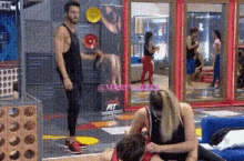 a man and a woman are playing a game in a gym with a sign that says fit