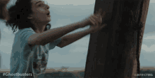 a ghostbusters animated gif of a boy reaching for a wooden pole