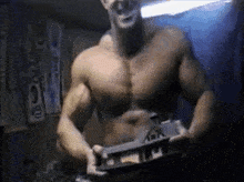 a shirtless man is holding a very large object in his hands .