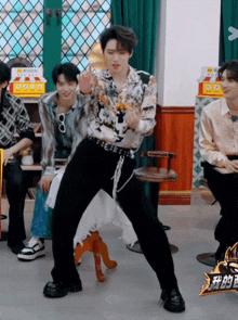 a man is dancing in front of a sign that says ' 我 的 王 '