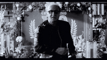 a black and white photo of a man in front of a wall that says cleaning
