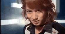 a woman with red hair is wearing a choker and playing cards on her chest .